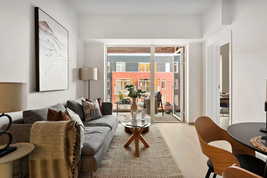 Sala de apartamento mobiliado, com luz natural e acesso à varanda